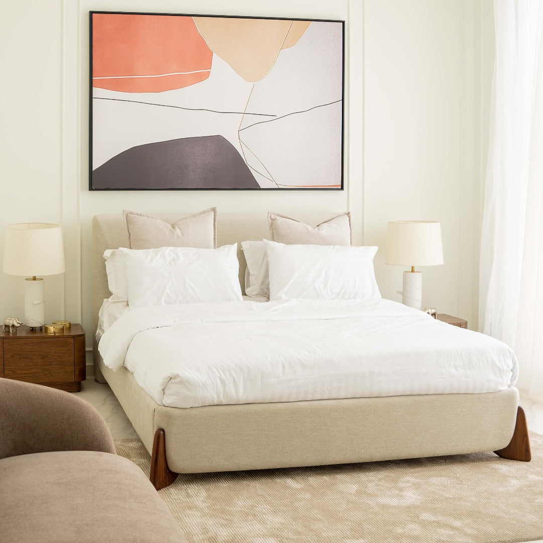 A bed featuring a unique boomerang-style Indian rosewood leg detail, adding a touch of exotic elegance to its design. The rich wood grain and distinctive shape of the legs create a striking visual contrast, enhancing the aesthetic appeal of the bed.