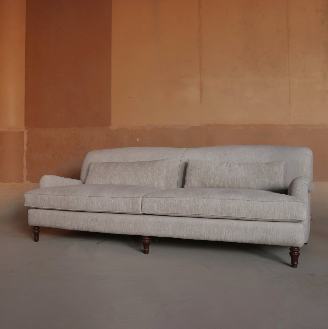 "Elegant three-seater sofa with a timeless design, featuring plush cushions, rolled arms, and classic wooden legs. Perfect for adding a touch of sophistication and comfort to any living space."