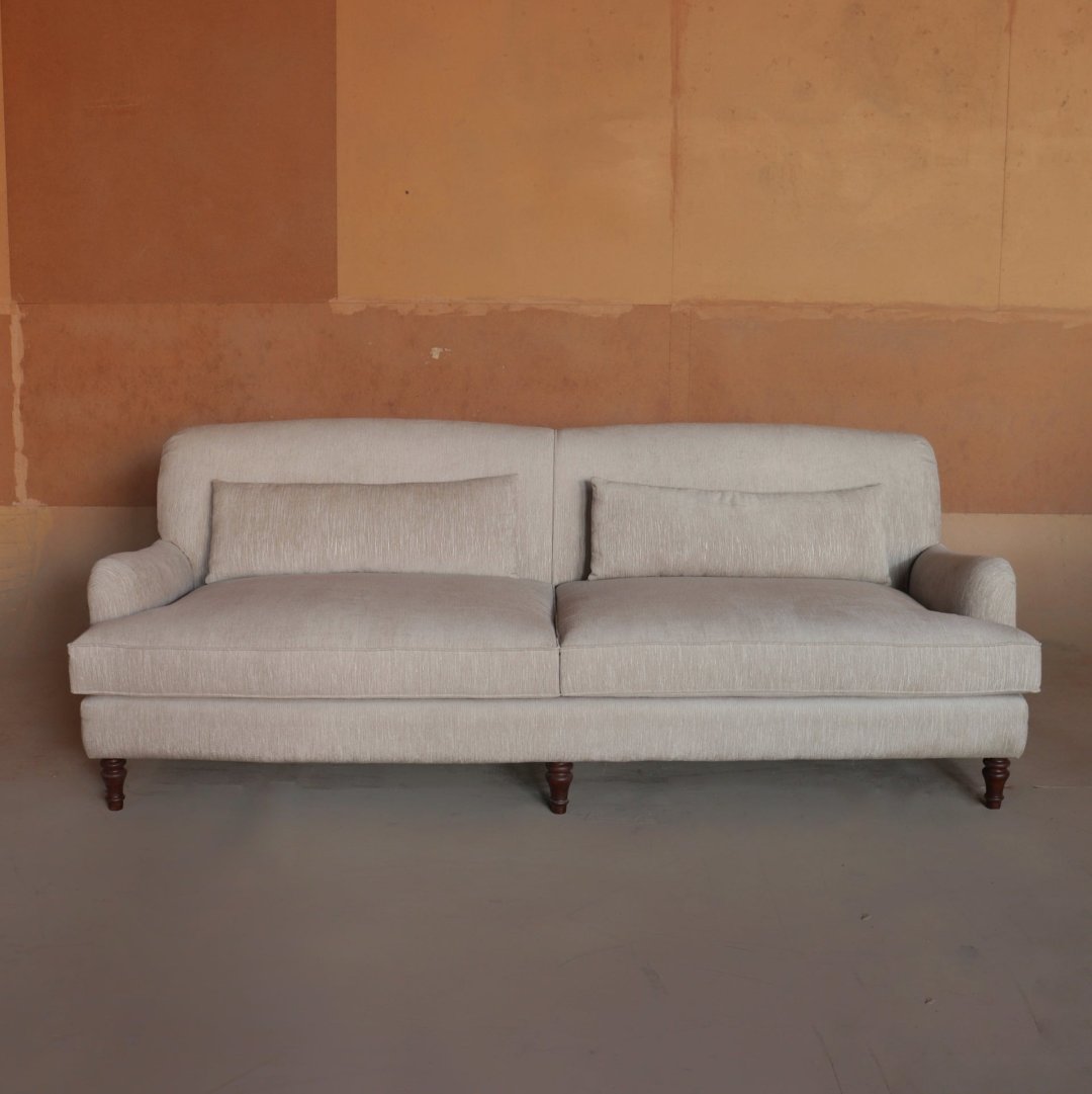 "Elegant three-seater sofa with a timeless design, featuring plush cushions, rolled arms, and classic wooden legs. Perfect for adding a touch of sophistication and comfort to any living space."