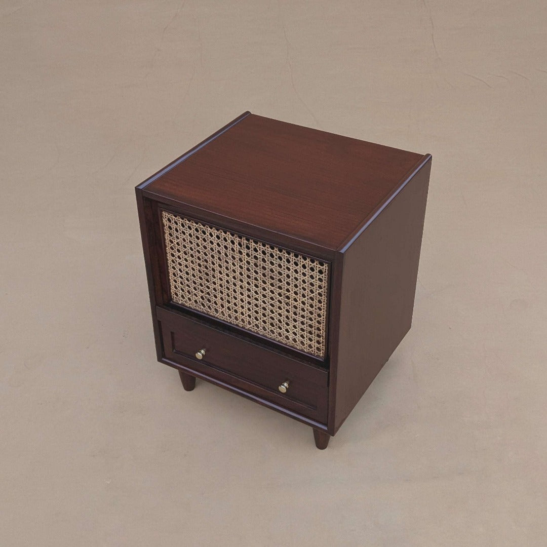 An end table featuring a cane-woven shelf, adding a touch of organic texture and visual interest to the room. The natural cane detailing complements the sleek lines of the table, creating a harmonious blend of modern and natural elements.