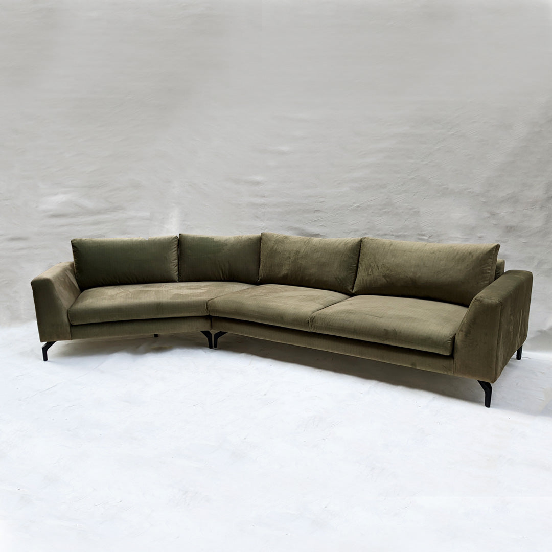 A cozy, angular lounge sofa upholstered in soft, textured fabric. Its contemporary design features clean lines and ample cushions, perfect for relaxation and casual gatherings.