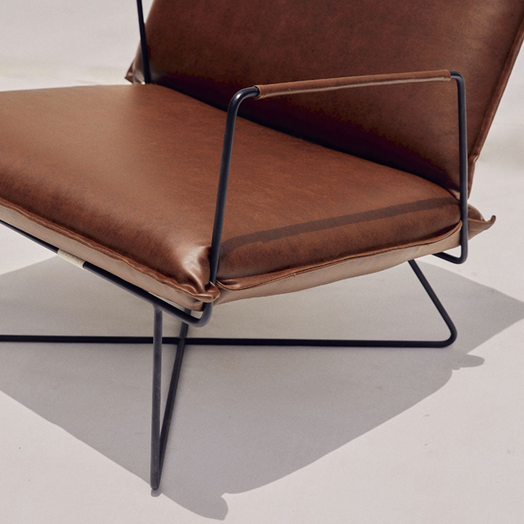A sleek chair crafted with leatherette upholstery and metal frame, epitomizing modern elegance. The smooth leatherette and polished metal seamlessly blend contemporary style with durability, making it a chic addition to any space.