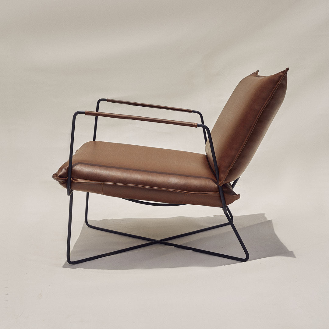 A sleek chair crafted with leatherette upholstery and metal frame, epitomizing modern elegance. The smooth leatherette and polished metal seamlessly blend contemporary style with durability, making it a chic addition to any space.