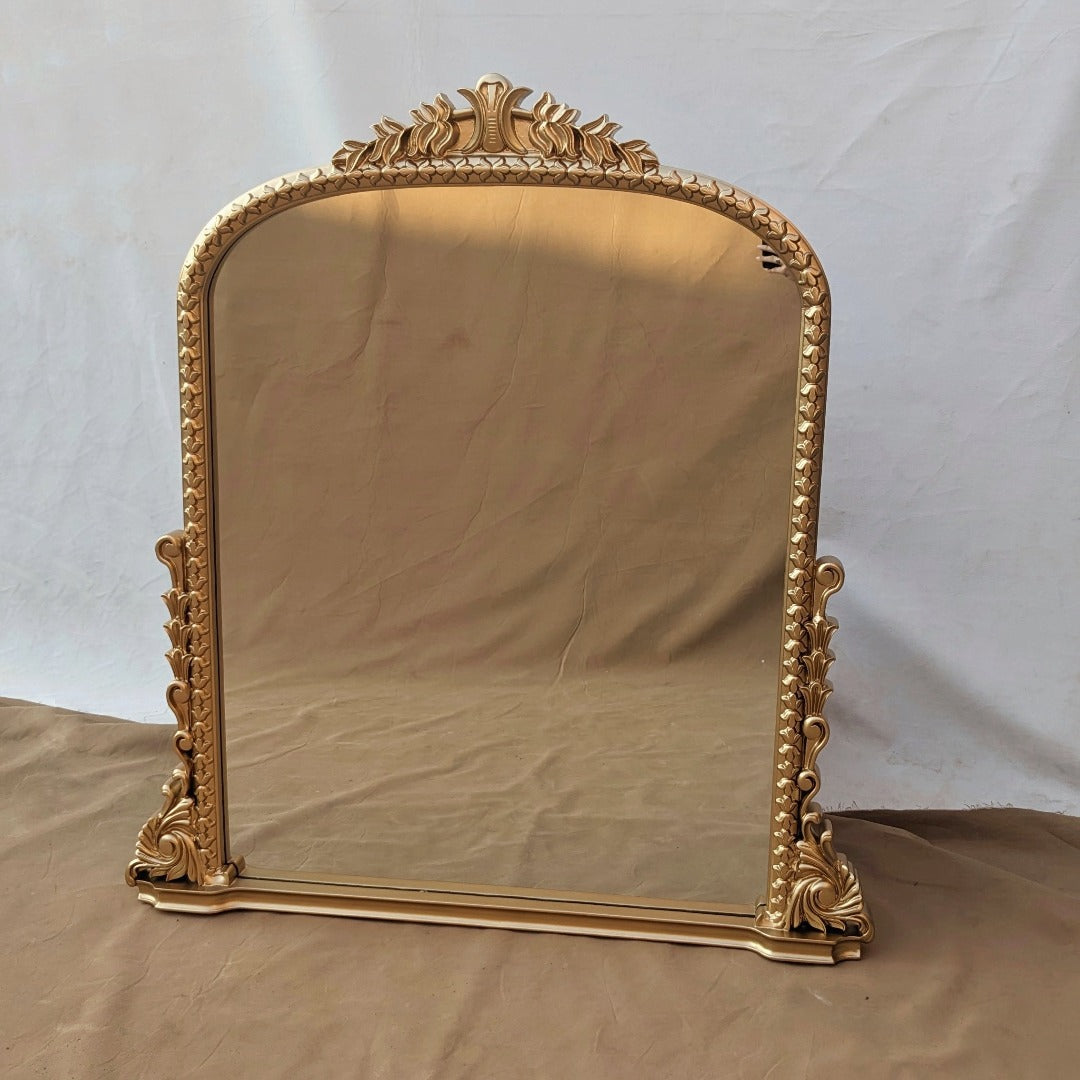 A handcrafted mirror from Anthropology, intricately carved with elaborate designs and motifs. Its artisanal beauty brings a touch of elegance and cultural richness to any space, reflecting light and enhancing the ambiance with its unique craftsmanship.