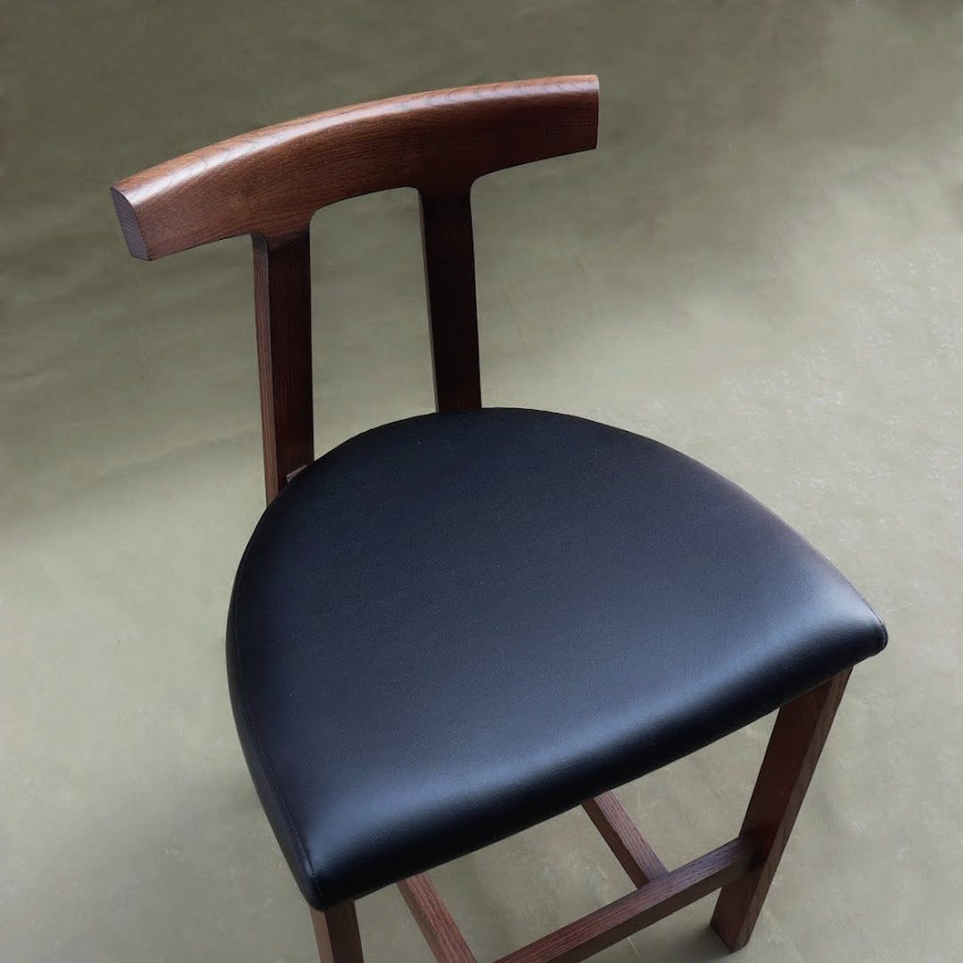 A bar stool, featuring a sleek design and comfortable seating, perfect for kitchen counters or home bars. Its minimalist silhouette and sturdy construction offer both style and functionality, making it an ideal seating option for casual dining or entertaining.