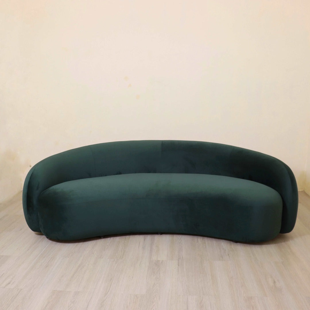 A curved cocoon couch, enveloping its occupants in comfort with its rounded design and plush upholstery. Its cocoon-like shape creates a cozy and intimate seating experience, perfect for lounging and relaxation in a modern living space.