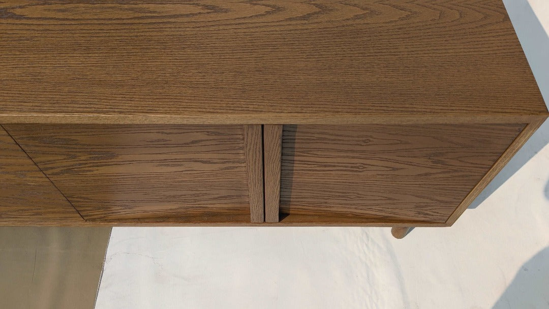 A console featuring red oak handles and red oak veneer, showcasing the natural beauty and warmth of the wood. The rich tones of the red oak complement the console's sleek design, adding a touch of elegance and sophistication to any space.