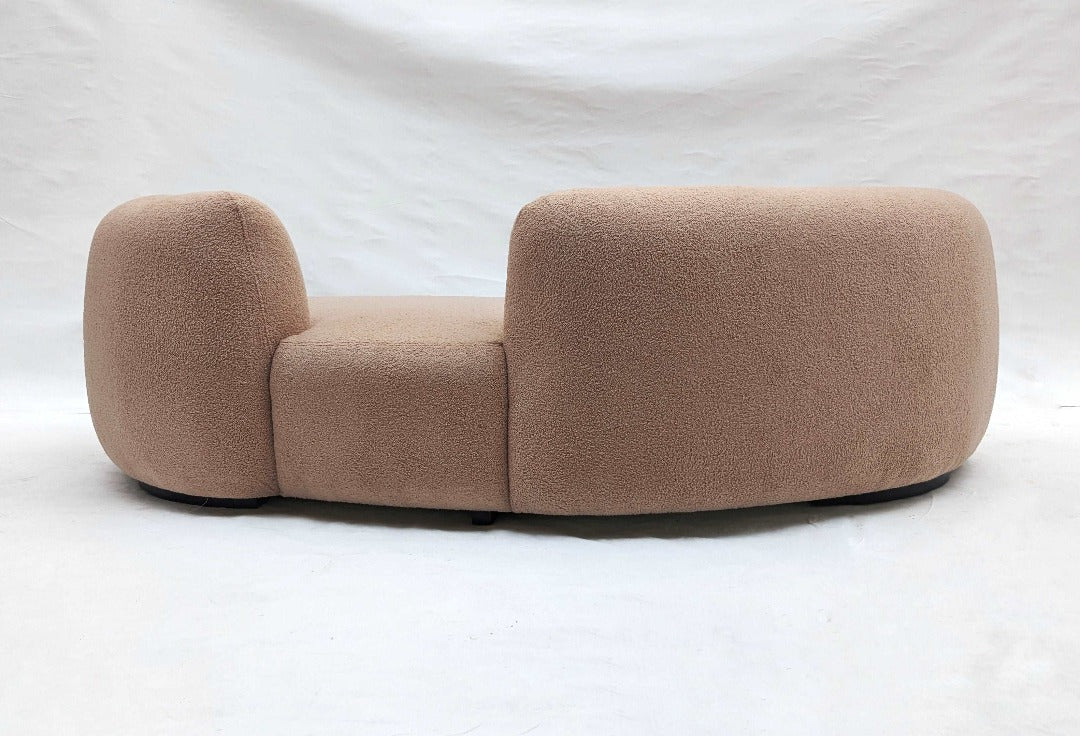 A curved cloud sofa, resembling a soft and inviting cloud with its gentle contours and plush upholstery. Its curved design and cushioned silhouette provide ultimate comfort and relaxation, creating a cozy and welcoming atmosphere in any living room.