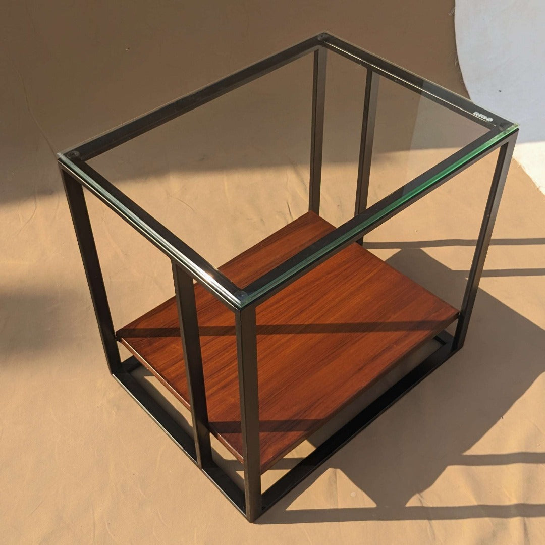 A side table with a steel frame and a tempered glass top, offering a modern and minimalist aesthetic. The sturdy steel frame provides stability, while the tempered glass surface adds a sleek and airy touch to the design, perfect for showcasing decorative items or providing a resting place for drinks and books.