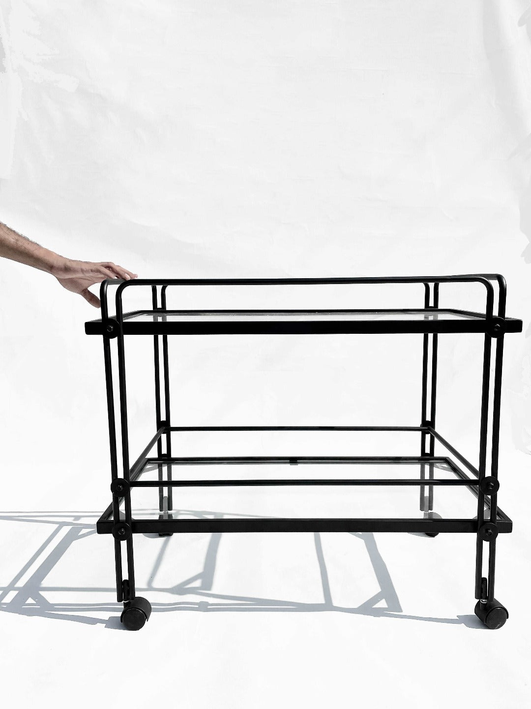 A sleek steel and tempered glass trolley, offering ample space for elegant entertaining