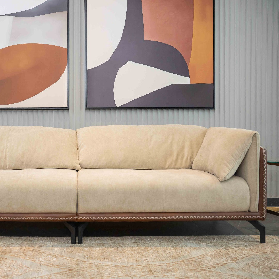 A hand-stitched sofa, crafted with meticulous attention to detail and upholstered in soft, luxurious fabric. Its generous cushions and ergonomic design offer exceptional comfort, inviting relaxation and conversation in any living room setting.